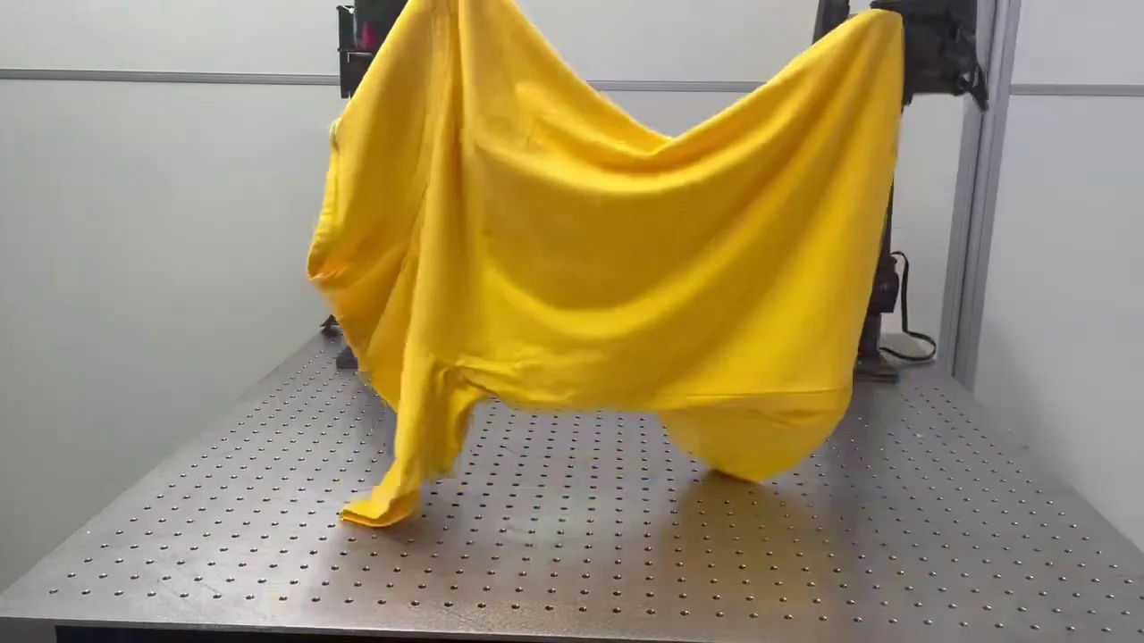 A yellow garment obscures the view of the robot during cloth folding.